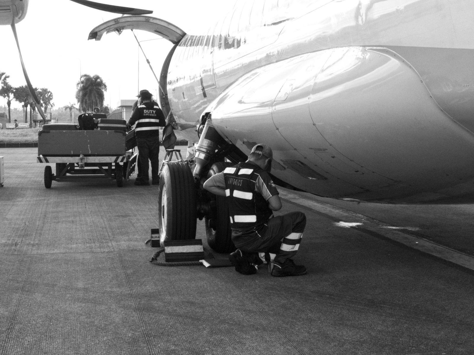 Engineers performing line maintenance beneath an aircraft