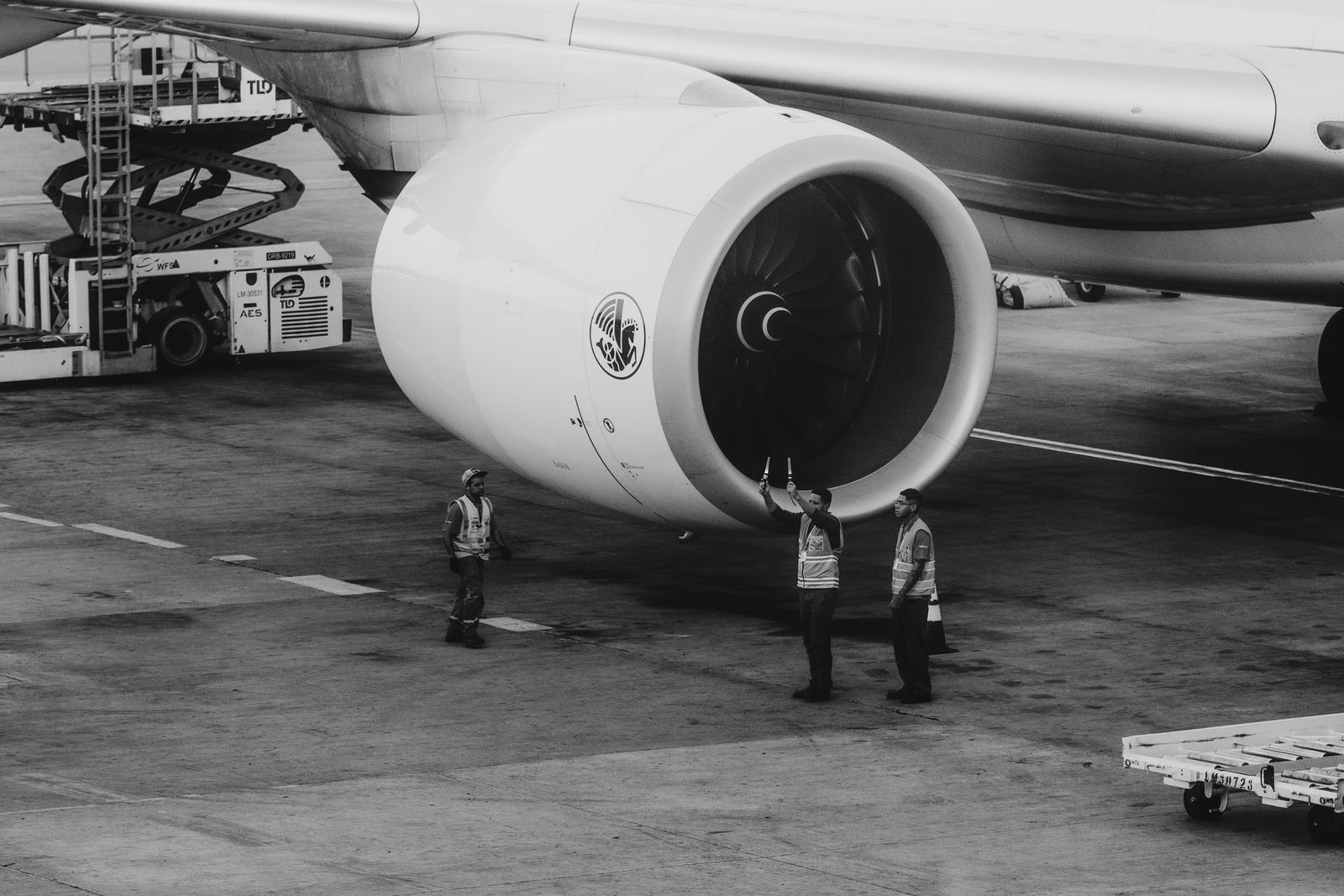 Ground crew signalling beneath a jet engine